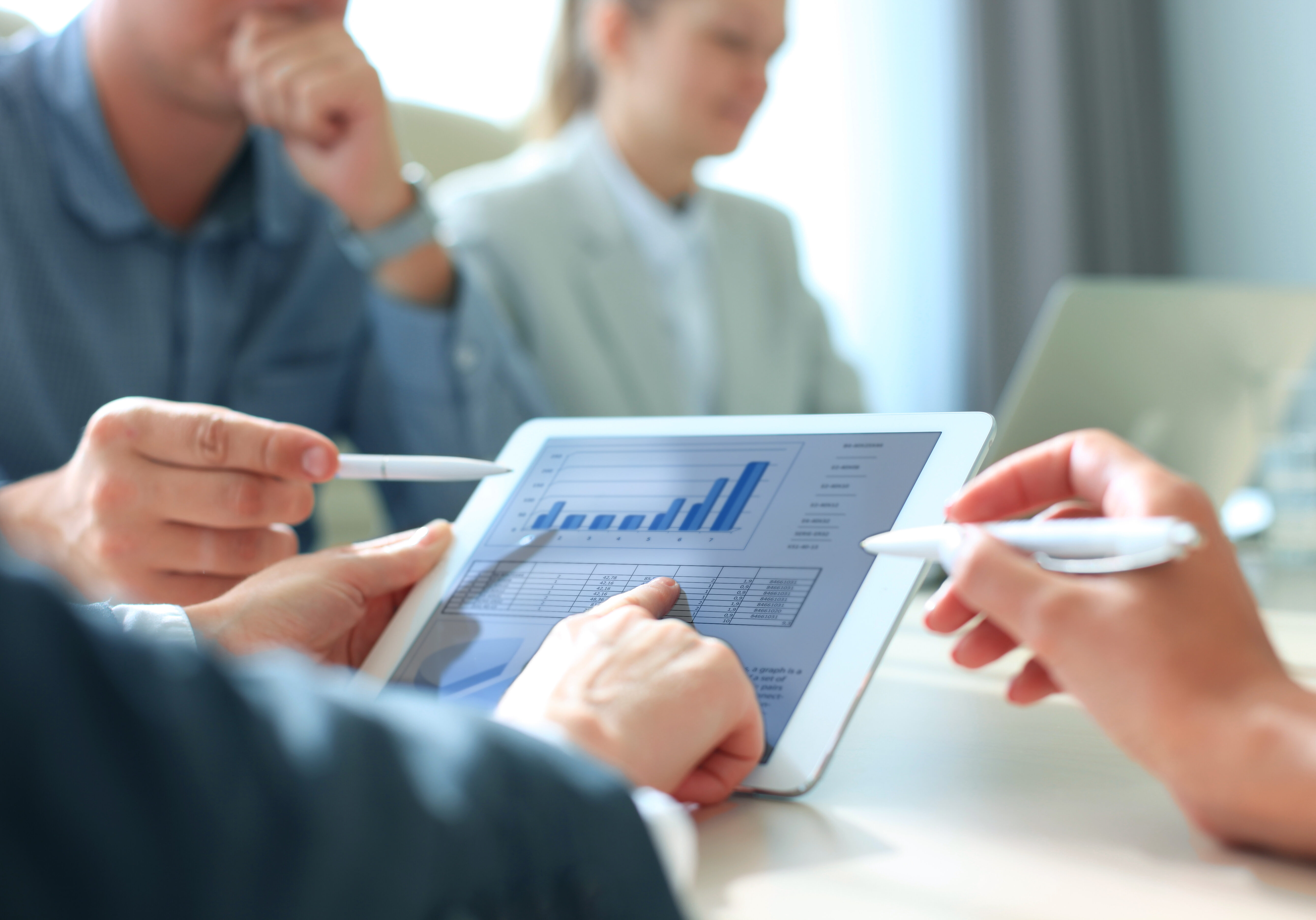 Business person analyzing financial statistics displayed on the tablet screen